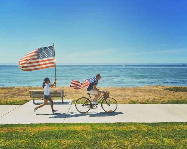 men and women running with american flag on 4th july